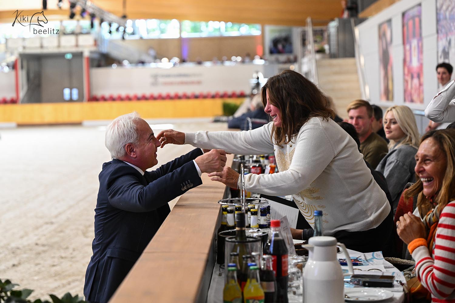 Ein Mann und eine Frau neigen sich zueinander für eine Umarmung bei einer Auktion